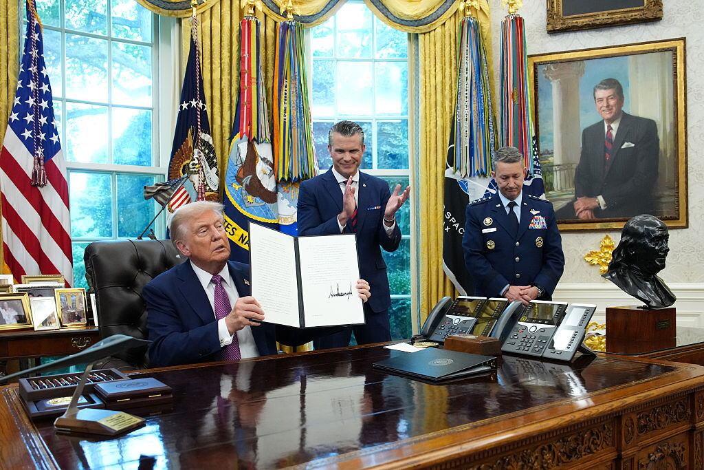 WASHINGTON, DC - SEPTEMBER 05: U.S. President Donald Trump displays a signed executive order renaming the Department of Defense as the Department of War as U.S. Defense Secretary Pete Hegseth (C) and Chairman of the Joint Chiefs of Staff Air Force Gen. Dan Caine (R) look on during a press availability in the Oval Office of the White House on September 05, 2025 in Washington, DC. President Trump signed executive orders which included the renaming of the Department of Defense to the Department of War. (Photo by Kevin Dietsch/Getty Images)