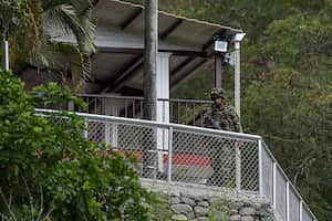 Soldiers stand guard at the farm where armed men fired against a group of youths, leaving five dead and two more wounded, in a rural area of Buga, Colombia on January 24, 2021. - This is the sixth massacre so far this year in the country, authorities reported. Despite the agreement with the FARC, the country is still in the midst of a conflict that has confronted guerrillas, state agents, paramilitaries and drug traffickers against each other for almost six decades, with a toll of more than nine million victims, including the dead, the disappeared and the displaced. (Photo by Luis ROBAYO / AFP)