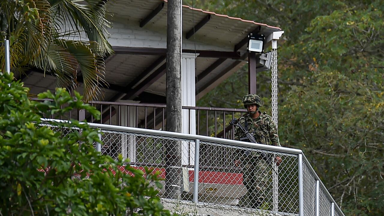 Soldiers stand guard at the farm where armed men fired against a group of youths, leaving five dead and two more wounded, in a rural area of Buga, Colombia on January 24, 2021. - This is the sixth massacre so far this year in the country, authorities reported. Despite the agreement with the FARC, the country is still in the midst of a conflict that has confronted guerrillas, state agents, paramilitaries and drug traffickers against each other for almost six decades, with a toll of more than nine million victims, including the dead, the disappeared and the displaced. (Photo by Luis ROBAYO / AFP)