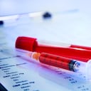 Informe de análisis de sangre hematológico con tubos de recogida de muestras de sangre y jeringa. Imagen de referencia.