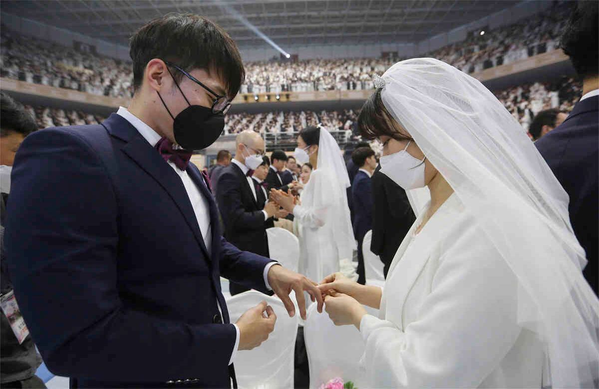 Una pareja, usando máscaras, intercambia sus anillos en una ceremonia de boda masiva en el Cheong Shim Peace World Center, en Corea del Sur, el 7 de febrero de 2020. Foto: Ahn Young-joon/ AP. 