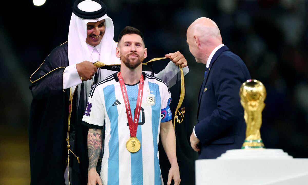 Soccer Football - FIFA World Cup Qatar 2022 - Final - Argentina v France - Lusail Stadium, Lusail, Qatar - December 18, 2022 Argentina's Lionel Messi, Emir of Qatar Sheikh Tamim bin Hamad Al Thani and FIFA president Gianni Infantino during the trophy ceremony REUTERS/Hannah Mckay