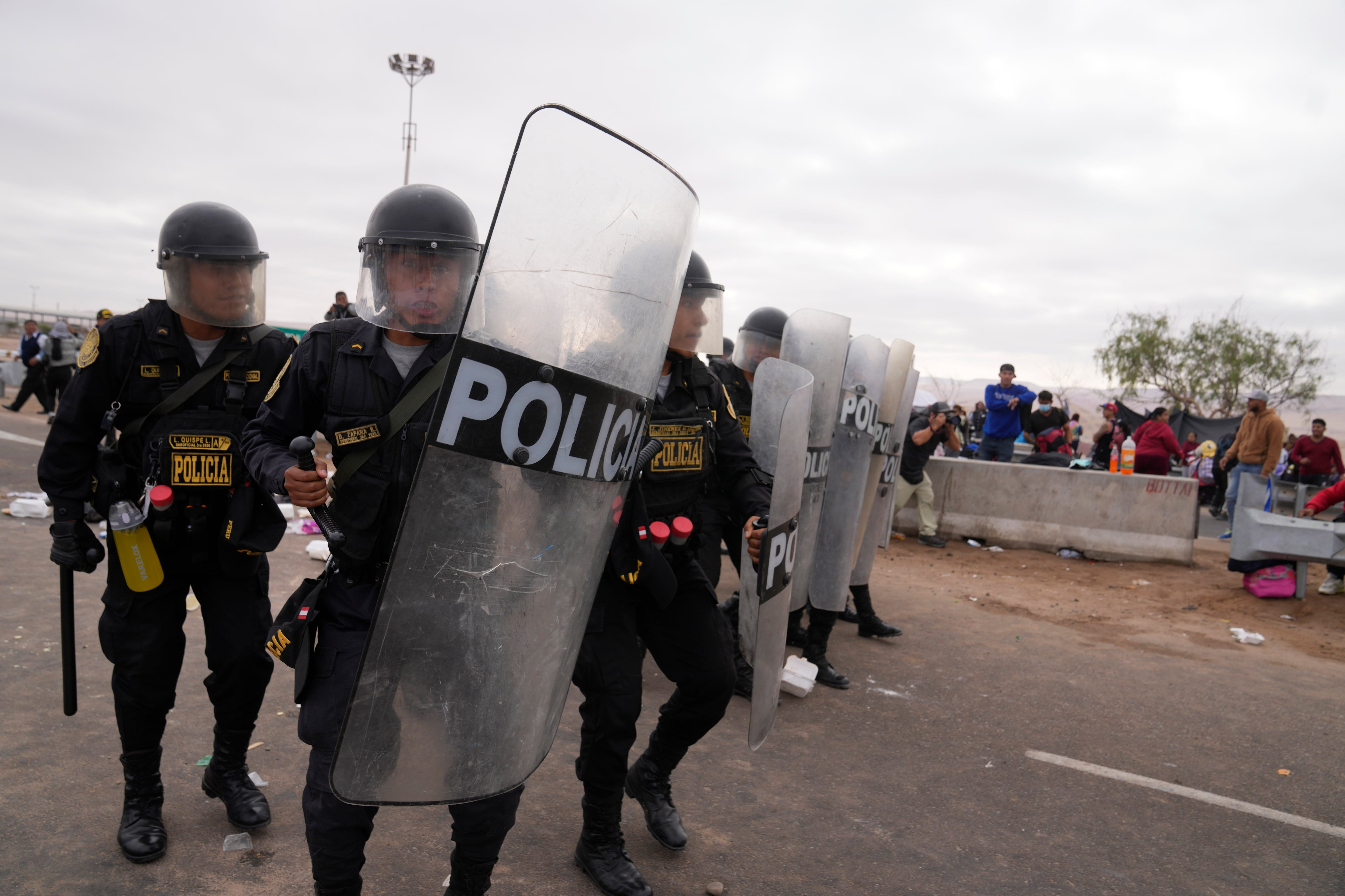 La policía marcha para dispersar a los migrantes venezolanos en la frontera peruana con Chile, en Tacna, Perú