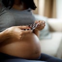 Mujer embarazada tomando pastillas en casa
