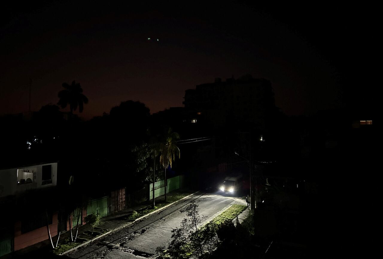 Las luces de un automóvil iluminan una calle durante un apagón general en La Habana el 14 de marzo de 2025. Cuba sufrió otro apagón general el 14 de marzo de 2025, causado por una falla en su sistema eléctrico nacional, según informó el Ministerio de Energía y Minas. (Foto de Yamil LAGE / AFP)