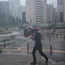 Un hombre intenta cubrirse con una sombrilla de las fuertes lluvias en Corea del Sur.