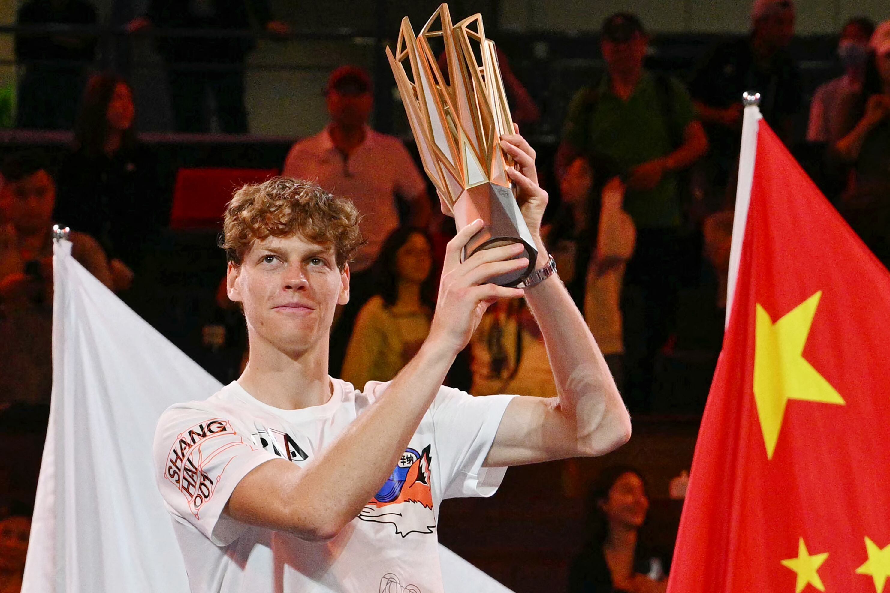 El italiano Jannik Sinner levanta el trofeo tras su victoria contra el serbio Novak Djokovic en la final individual masculina del torneo de tenis Masters de Shanghái en Shanghái el 13 de octubre de 2024. (Foto de HECTOR RETAMAL / AFP)