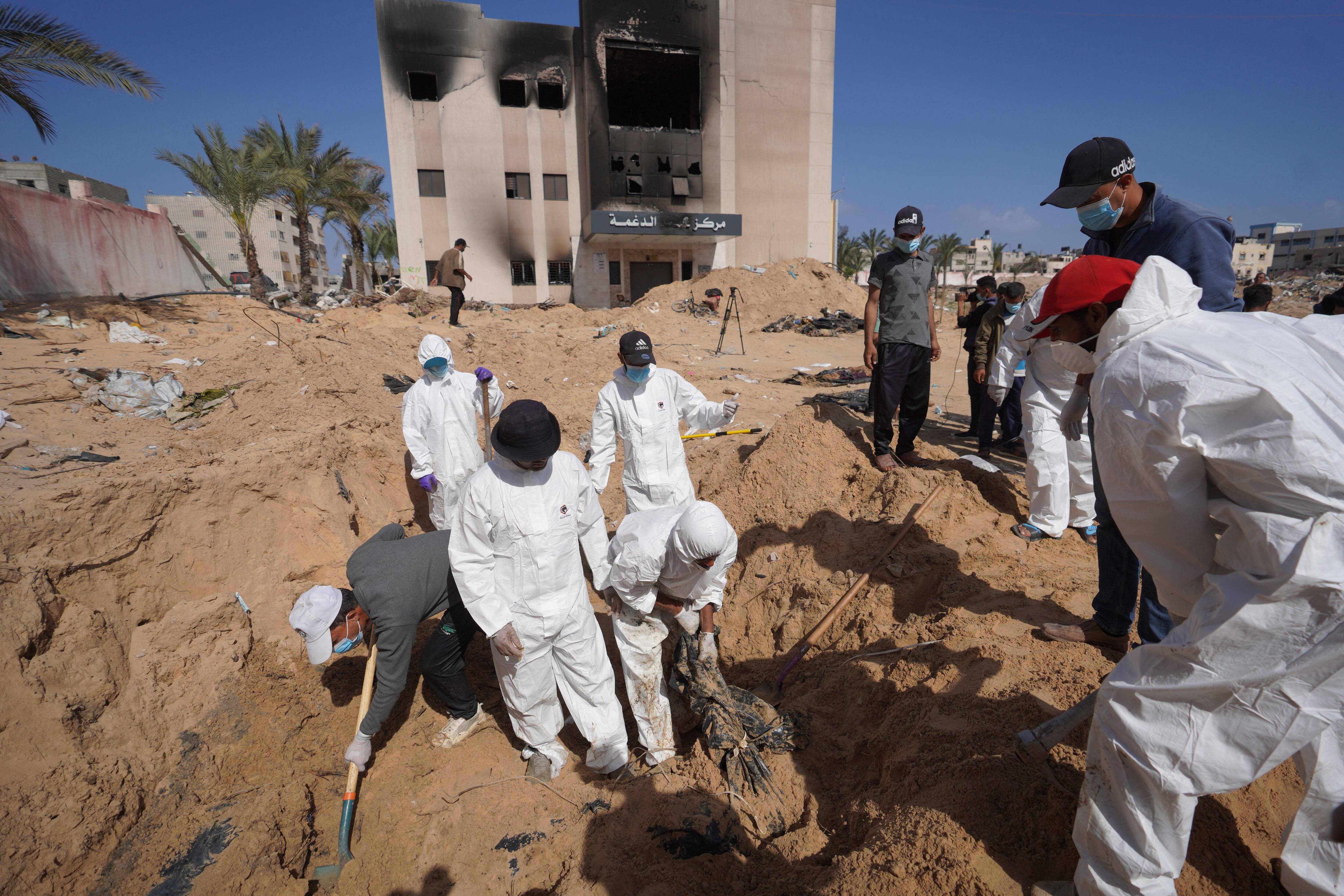 Trabajadores de la salud palestinos desentierran un cuerpo enterrado por las fuerzas israelíes en el recinto hospitalario Nasser en Khan Yunis, en el sur de la Franja de Gaza, el 21 de abril de 2024