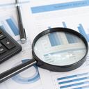 planificación de negocios e inversiones. Lupa con informe comercial en el escritorio del asesor financiero. Concepto de análisis de datos, contabilidad, auditoría, investigación empresarial.