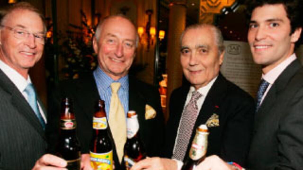 Julio Mario Santo Domingo y su hijo Alejandro el día que cerraron el negocio, con Graham Mackay (centro), presidente de SABMiller, y Malcom Wylman, vicepresidente financiero de SABMiller