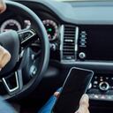 Hombre revisa su celular en el carro