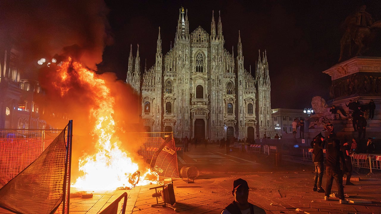 Fuego en la Catedral de Milán durante las protestas en Italia.
