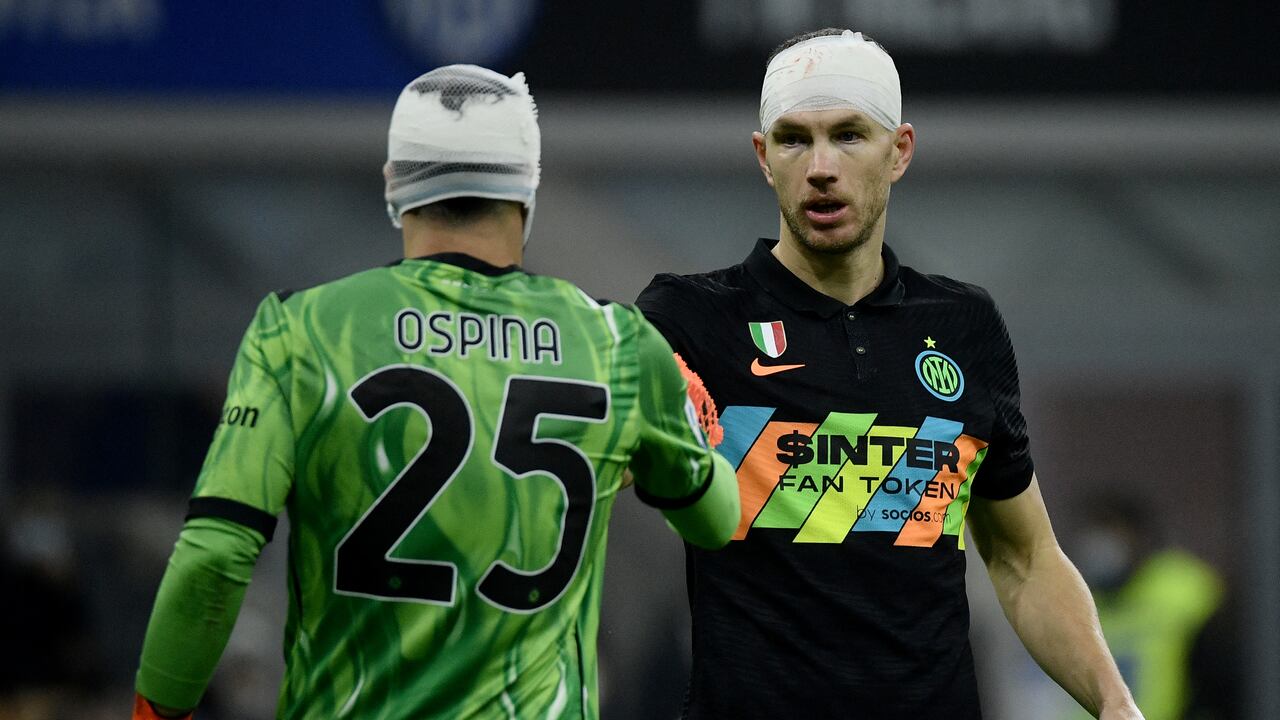 Inter Milan's Bosnian forward Edin Dzeko (R) reacts with Napoli's Colombian goalkeeper David Ospina (L) during the Italian Serie A football match between Inter and Napoli, at the San Siro Stadium in Milan, on November 21, 2021. (Photo by Filippo MONTEFORTE / AFP)