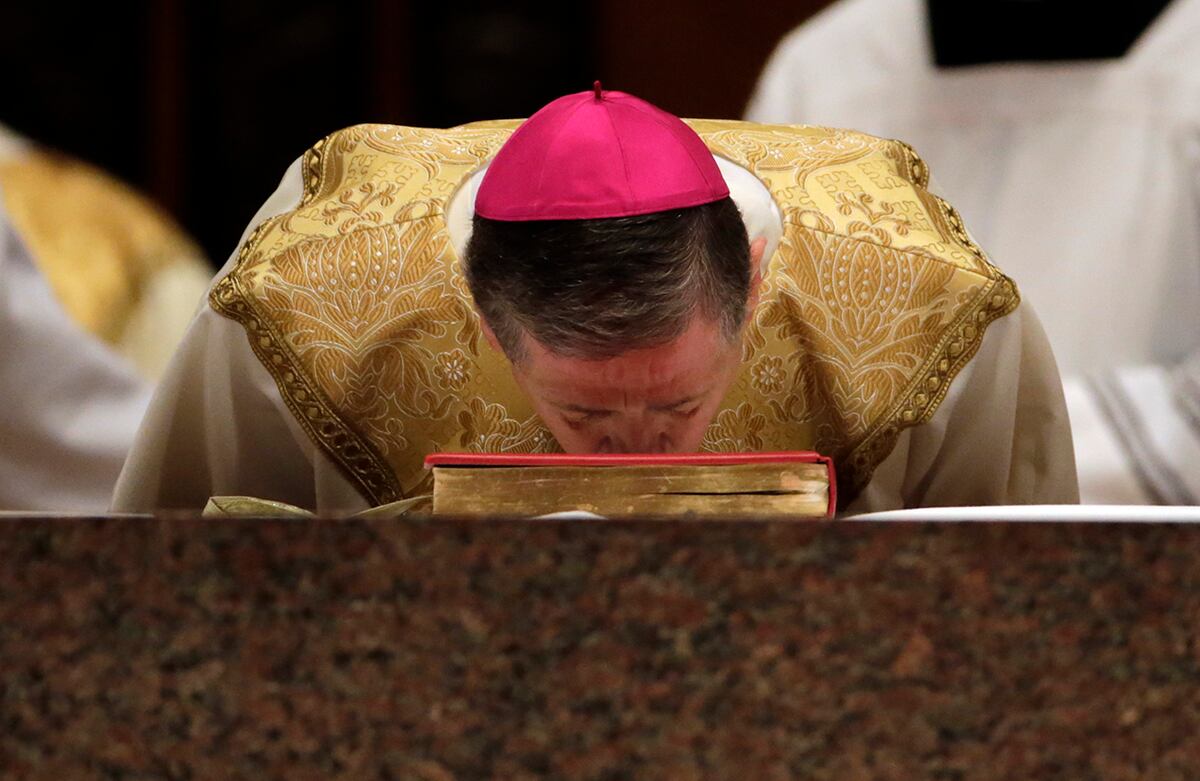 El arzobispo Blase Cupich besa una biblia durante una misa en la catedral Holy Name, en Chicago, Estados Unidos. (AP)