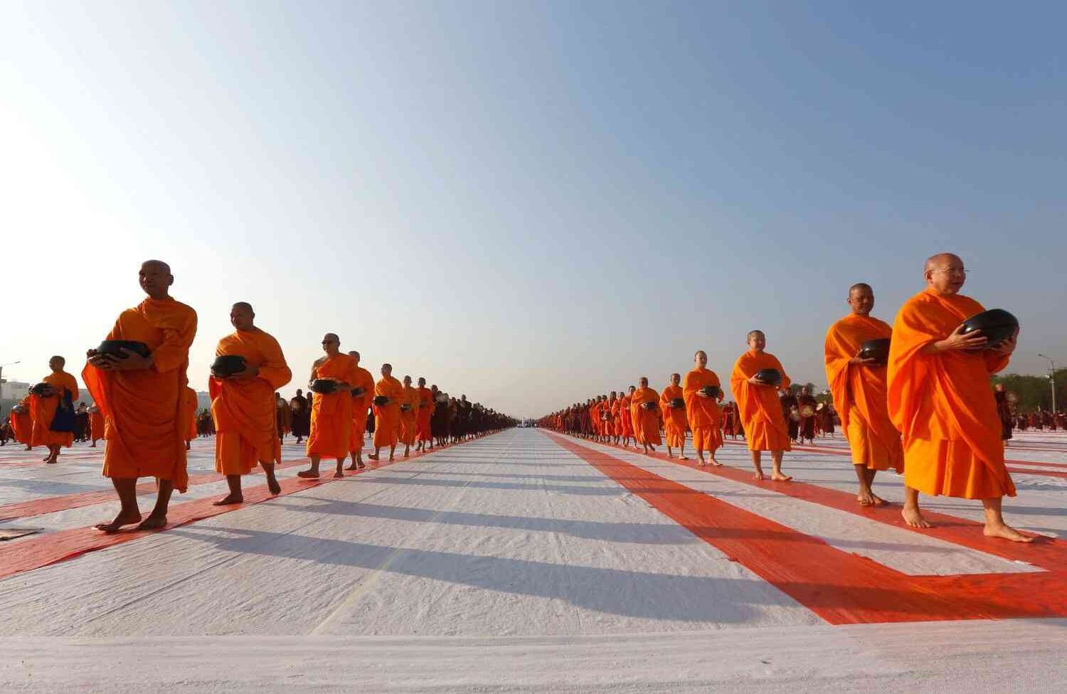 Myanmar y los monjes budistas tailandeses participan en una ceremonia de ofrenda de limosnas en Mandalay el 21 de enero de 2018. / AFP PHOTO / THET AUNG.