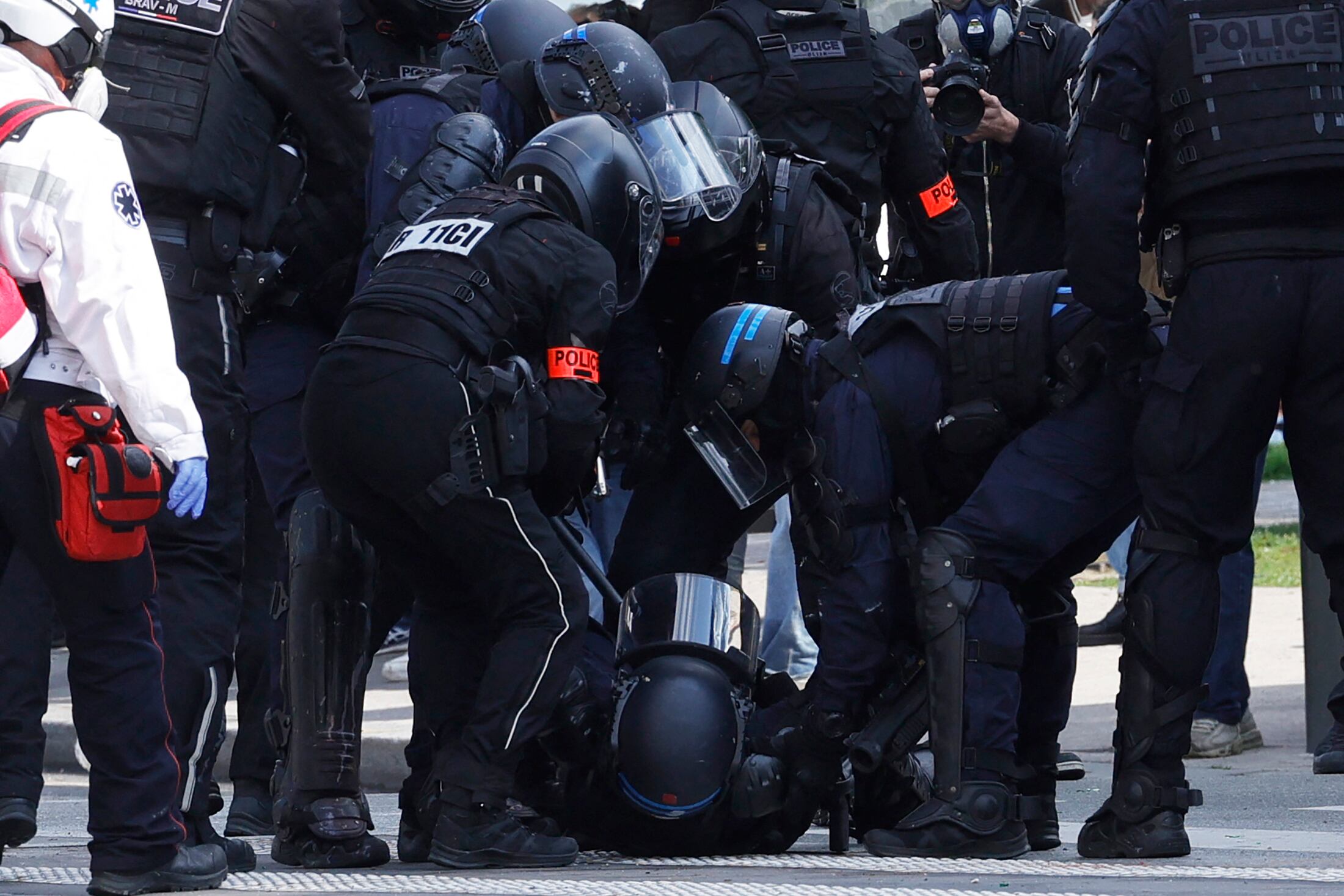 Los policías ayudan a un colega presuntamente herido durante una manifestación el Primero de Mayo (Día del Trabajo), para conmemorar el día internacional de los trabajadores, más de un mes después de que el gobierno aprobara una impopular ley de reforma de las pensiones en el parlamento, en París, el 1 de mayo. 2023. - Los partidos de oposición y los sindicatos han instado a los manifestantes a mantener su campaña de tres meses contra la ley que aumentará la edad de jubilación de 62 a 64. (Foto de Geoffroy VAN DER HASSELT / AFP)