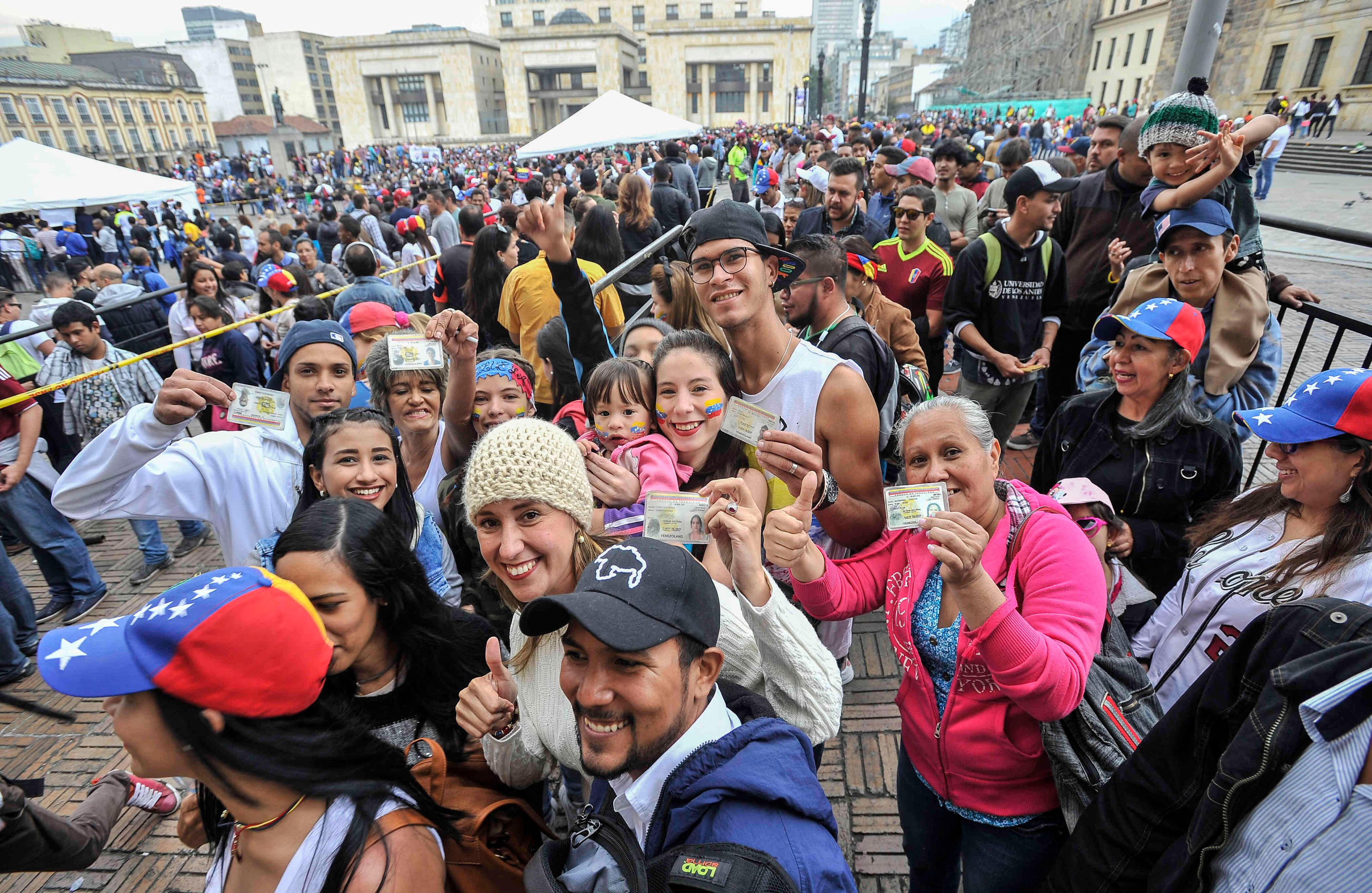 Ciudadanos venezolanos —residentes en Bogotá— muestran su documento de identidad antes de sufragar en la Plaza de Bolívar,  el domingo 16 de julio de 2017, en Colombia, durante las votaciones al plebiscito. Esta jornada democrática ha sido  impulsada  por la oposición al gobierno de Nicolás Maduro. En las tarjetas, los ciudadanos deben responder ‘sí’ o ‘no’ a tres preguntas: la primera es si respalda el plan del presidente Nicolás Maduro de cambiar la Constitución; la segunda es si  apoya la intervención de las Fuerzas Armadas para “restituir el orden constitucional” y por último si desea un gobierno de unidad nacional. Foto: Carlos Julio Martínez / 