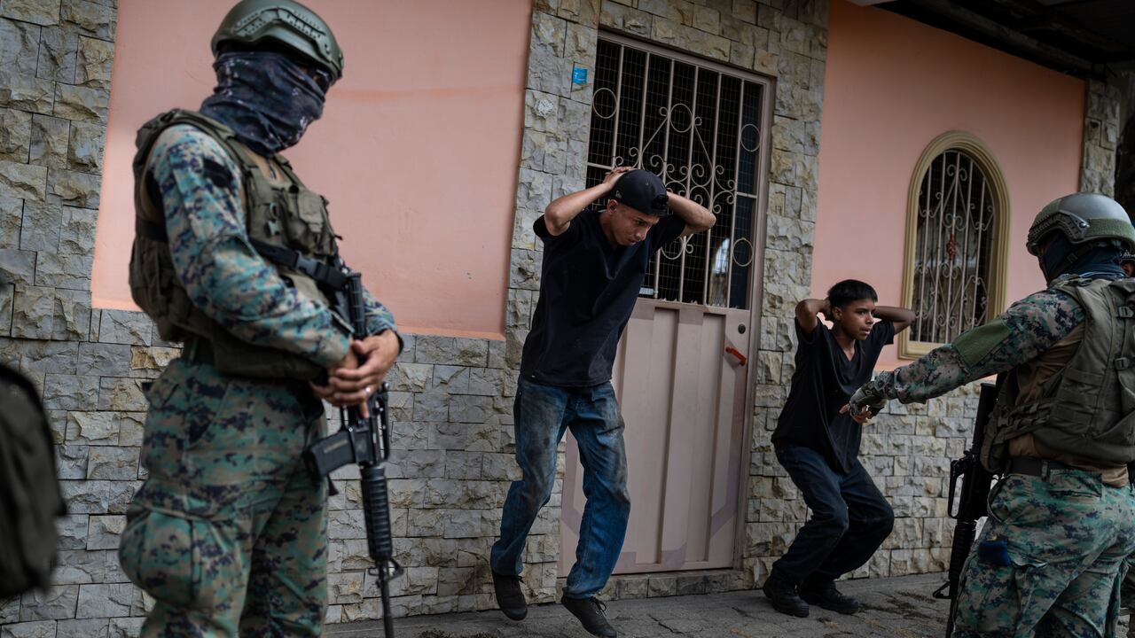 Dos soldados obligan a dos hombres a ejercitarse como castigo por no traer las licencias adecuadas para sus motocicletas, el sábado 30 de septiembre de 2023, en Durán, ciudad hermana de Guayaquil, Ecuador. (AP Foto/Rodrigo Abd)
