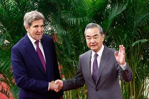 El enviado climático de EE. UU., John Kerry, y el director de la Oficina de la Comisión de Asuntos Exteriores del Comité Central del Partido Comunista de China, Wang Yi (R), se dan la mano antes de una reunión en el Gran Salón del Pueblo en Beijing el 18 de julio de 2023. (Foto por FLORENCIA LO / PISCINA / AFP)