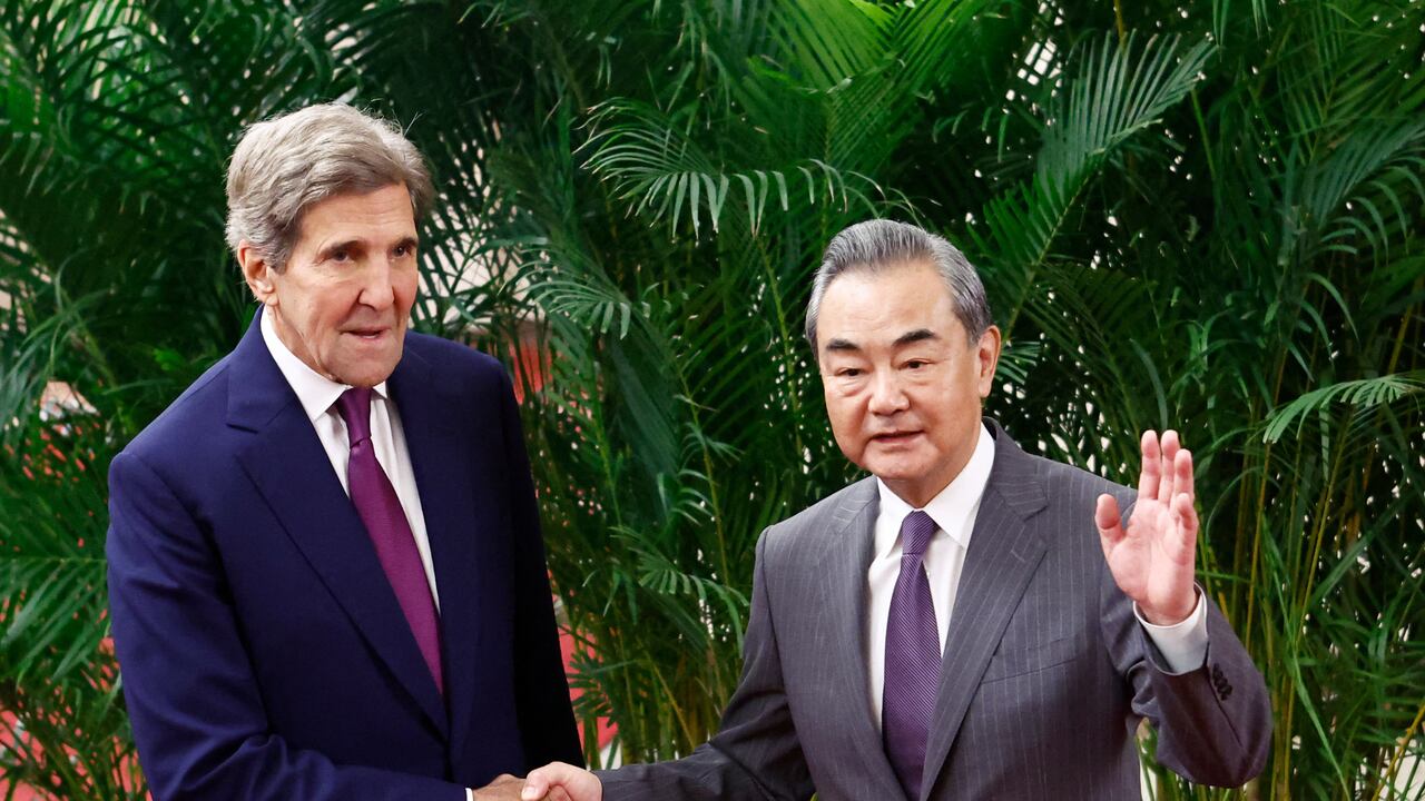 El enviado climático de EE. UU., John Kerry, y el director de la Oficina de la Comisión de Asuntos Exteriores del Comité Central del Partido Comunista de China, Wang Yi (R), se dan la mano antes de una reunión en el Gran Salón del Pueblo en Beijing el 18 de julio de 2023. (Foto por FLORENCIA LO / PISCINA / AFP)