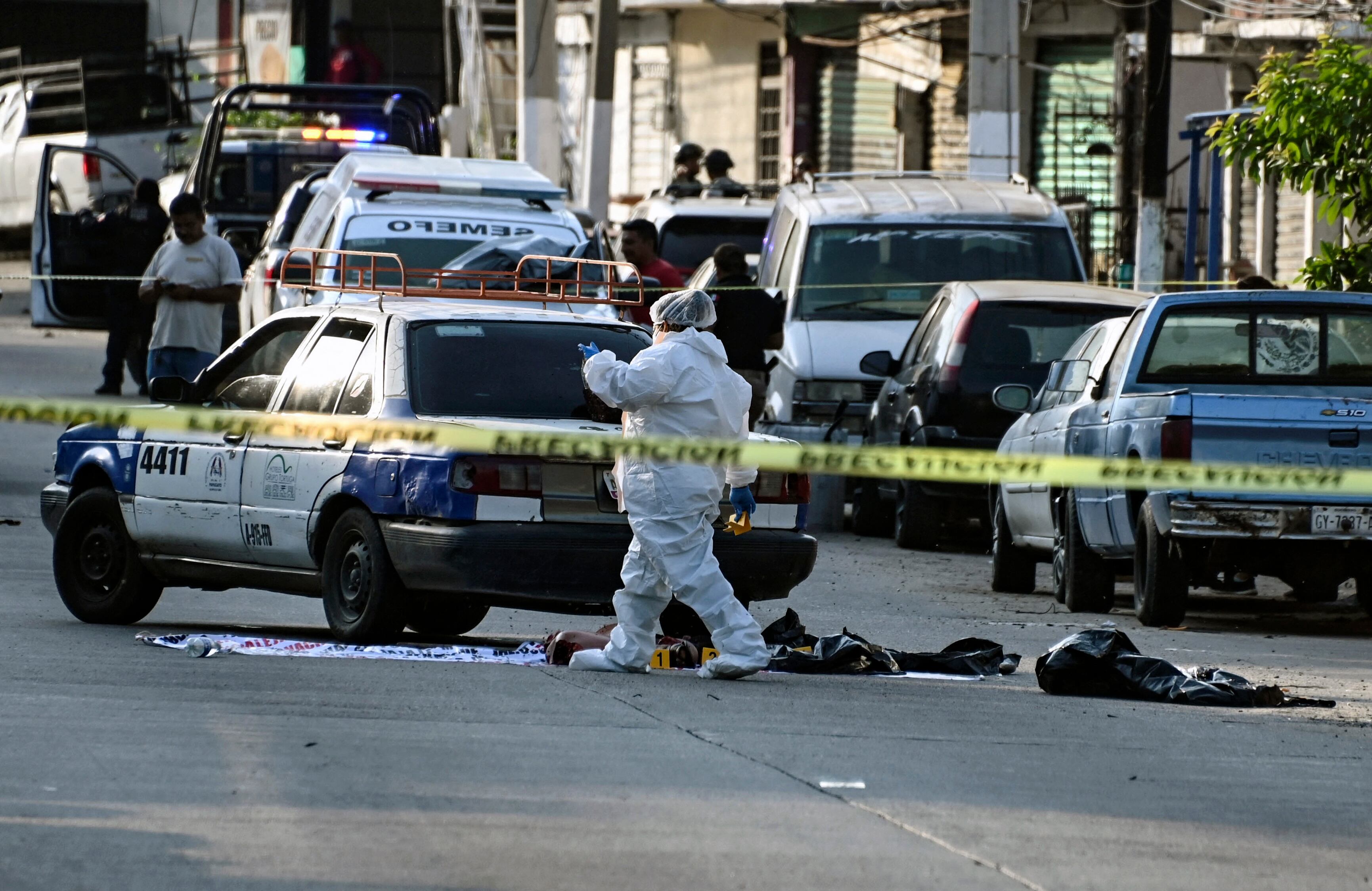 Personal forense trabaja en el sitio donde fueron abandonados pedazos de cuerpo humano en la ciudad portuaria turística de Acapulco, estado de Guerrero, México, el 7 de julio de 2024.