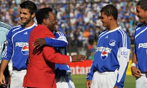 BOGOTA, COLOMBIA - JANUARY 17: Brazilian football legend Pele hugs a group of football players of Colombian Millonarios team during his visit to promote Libertadores Cup 2010 before the match betwen Milinarios v Independientes Santa Fe at El Campin Stadium on January 17, 2010 in Bogota, Colombia. (Photo by Gal Schweizer/LatinContent via Getty Images)