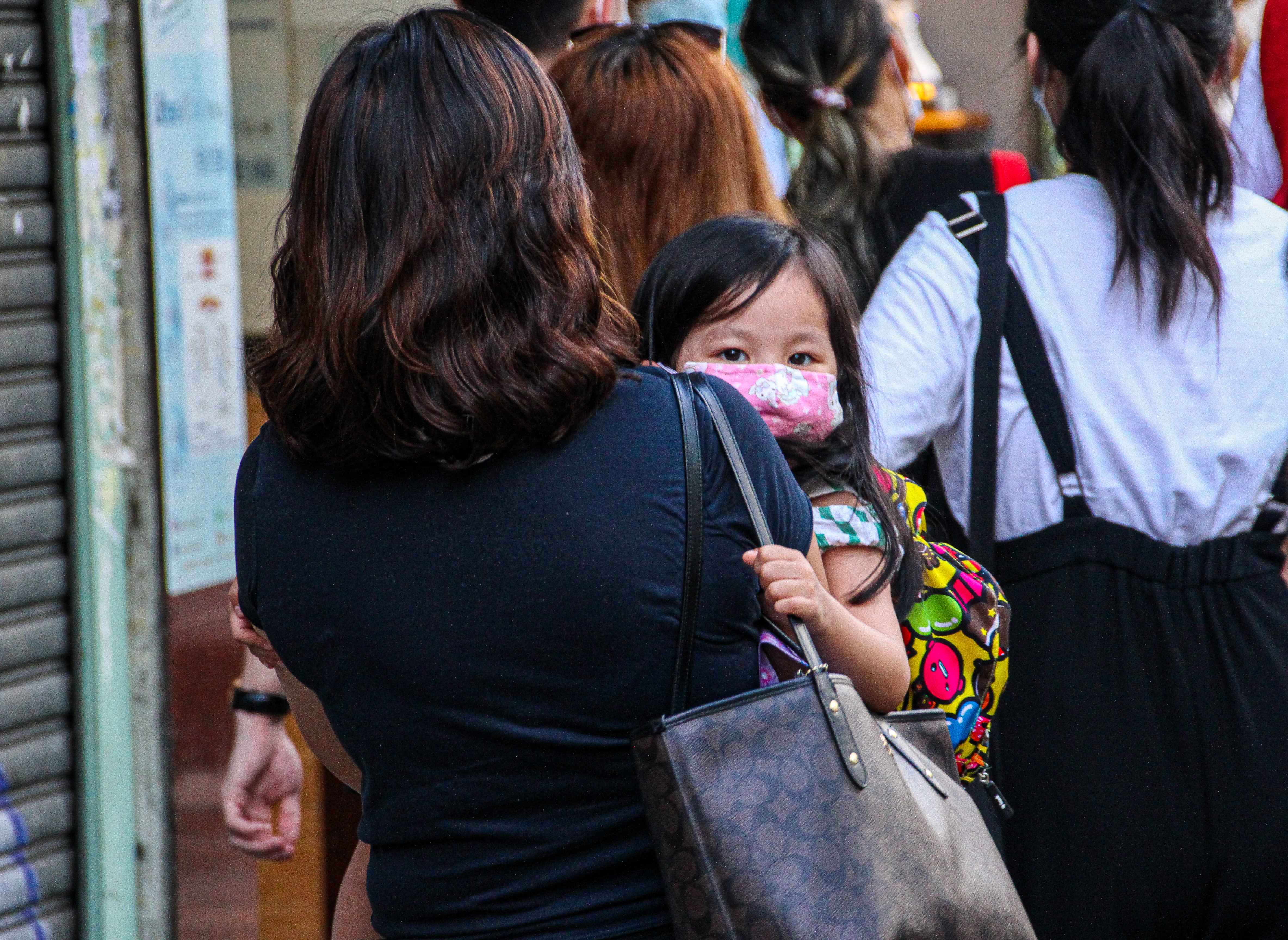 Una madre aleja a su hijo pequeño de la multitud durante las protestas callejeras en Mongkok, Hong Kong, el 28 de junio de 2020