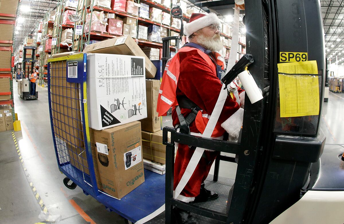 Vestido como Papá Noel, el trabajador Glenn Wright traslada artículos en el centro de envíos de Amazon en Tennessee, Estados Unidos. (AP)