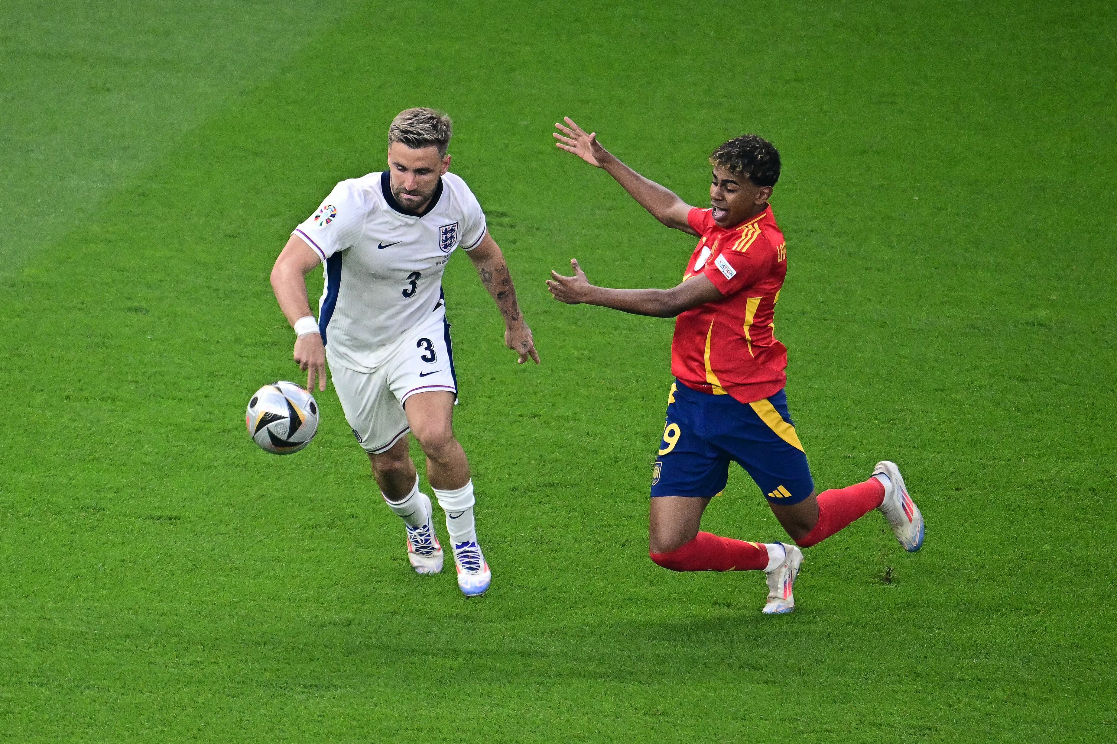 El delantero español #19 Lamine Yamal reacciona tras una entrada del defensa inglés #03 Luke Shaw durante el partido de fútbol de la final de la UEFA Euro 2024 entre España e Inglaterra en el Olympiastadion de Berlín.
