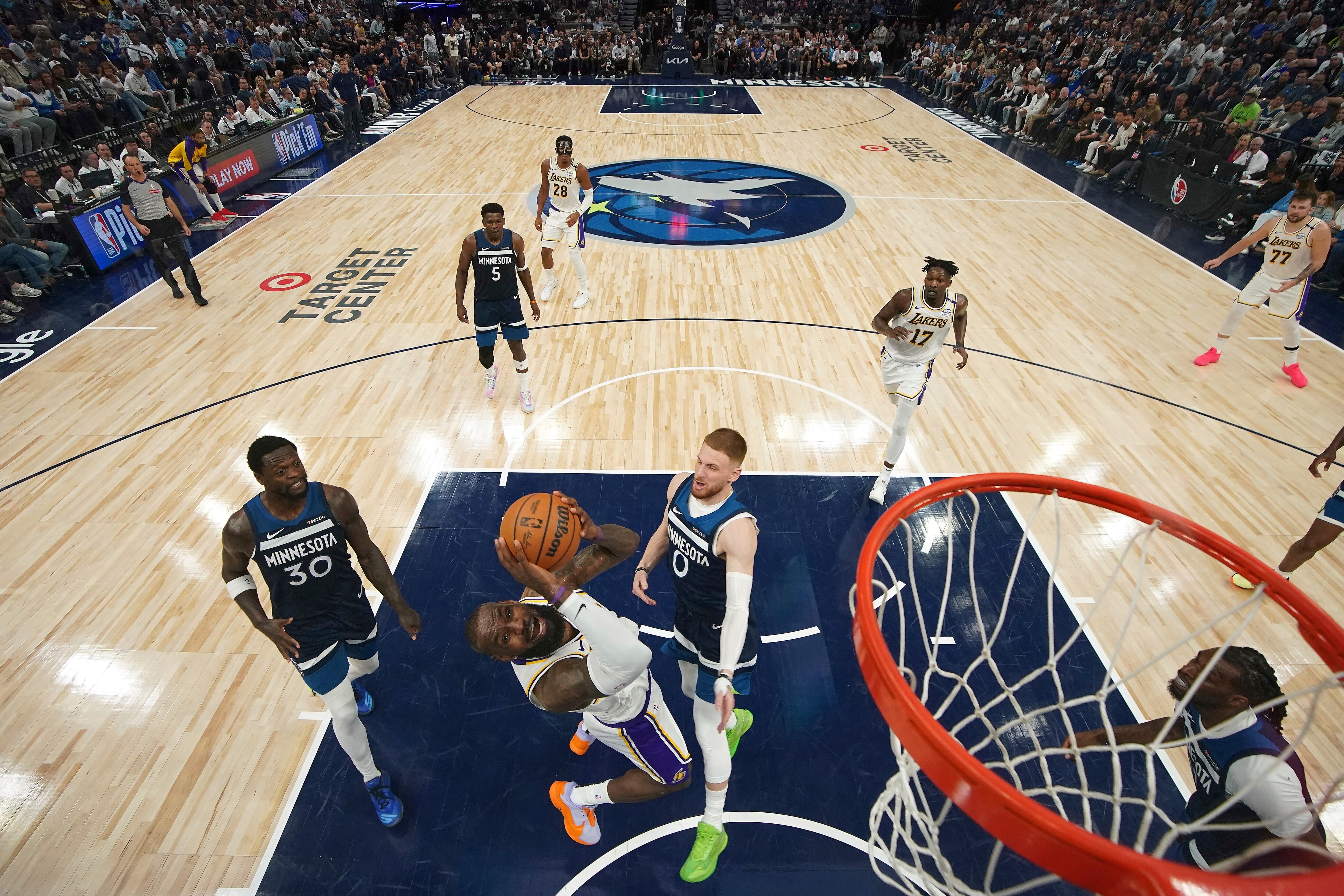 Los Angeles Lakers forward LeBron James, second from bottom left, goes up to shoot as Minnesota Timberwolves guard Donte DiVincenzo (0) defends during the first half of Game 4 of an NBA basketball first-round playoff series, Sunday, April 27, 2025, in Minneapolis. (AP Photo/Abbie Parr)