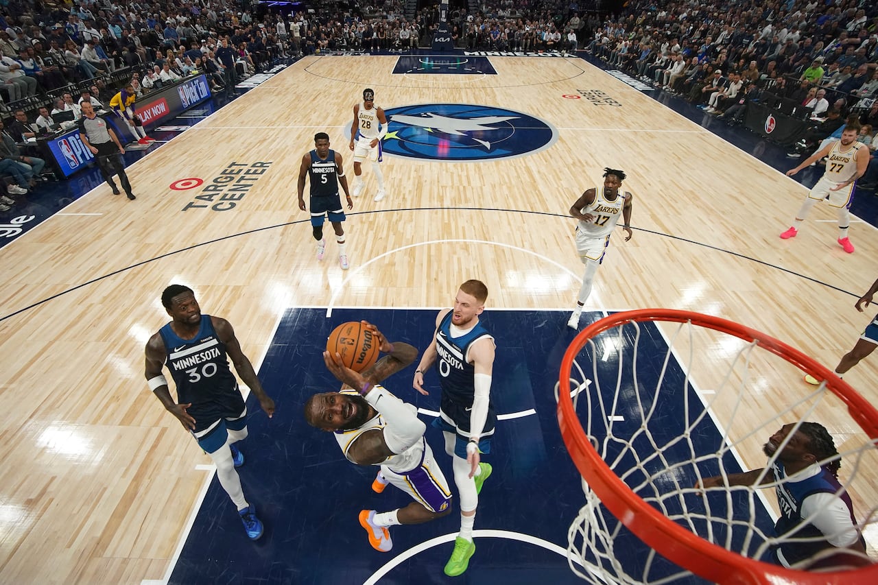 Los Angeles Lakers forward LeBron James, second from bottom left, goes up to shoot as Minnesota Timberwolves guard Donte DiVincenzo (0) defends during the first half of Game 4 of an NBA basketball first-round playoff series, Sunday, April 27, 2025, in Minneapolis. (AP Photo/Abbie Parr)