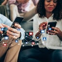 Grupo multiétnico de jóvenes sentados en las escaleras y usando teléfonos celulares, Joven sonriente recibe notificaciones en teléfonos inteligentes. Medios de comunicación social y concepto digital en línea. Concepto de tecnología de redes sociales y personas. Redes Sociales.