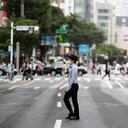 Un hombre con mascarilla cruza una calle en el popular barrio comercial de Ginza, en Tokio, el 21 de mayo de 2021. (AP Foto/Hiro Komae)