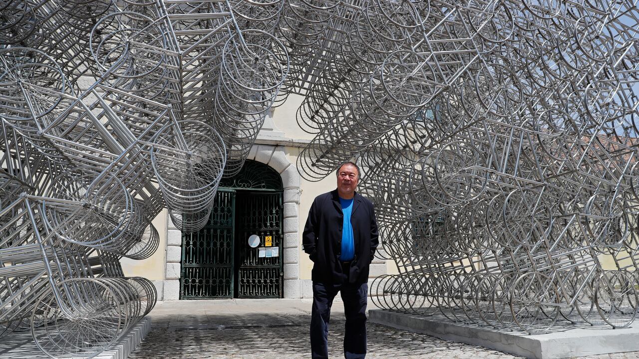 El artista chino disidente Ai Weiwei posa junto a su escultura "Forever Bicycles" durante un avance de prensa de su nueva exposición "Rapture" en Lisboa, el jueves 3 de junio de 2021. AP Photo/Armando Franca