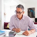 Mature man wearing eyeglasses working on personal finances at home
