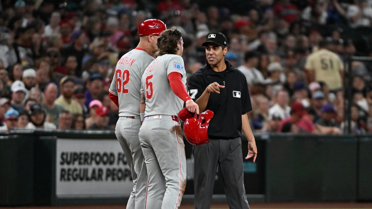 PHOENIX, ARIZONA - SEPTEMBER 20: Bryson Stott #5 and third base coach Dusty Wathan #62 of the Philadelphia Phillies argue with third base umpire Gabe Morales #47 during the fifth inning against the Arizona Diamondbacks at Chase Field on September 20, 2025 in Phoenix, Arizona. (Photo by Norm Hall/Getty Images)