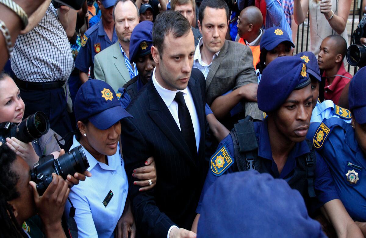 Escortado por policías y seguridad, el atleta Oscar Pistorius deja la corte en Pretoria, Suráfrica, luego de haber sido culpado por homicidio. (AP)