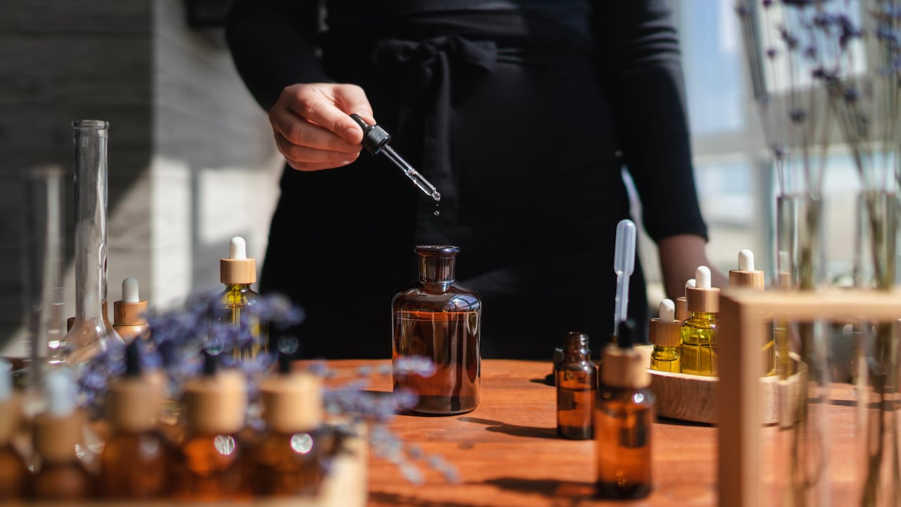 Frascos y botellas con diferentes tipos de aceites, flores de lavanda y esencias.