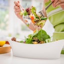 mujer hispana, tirar, ensalada, en, cocina doméstica