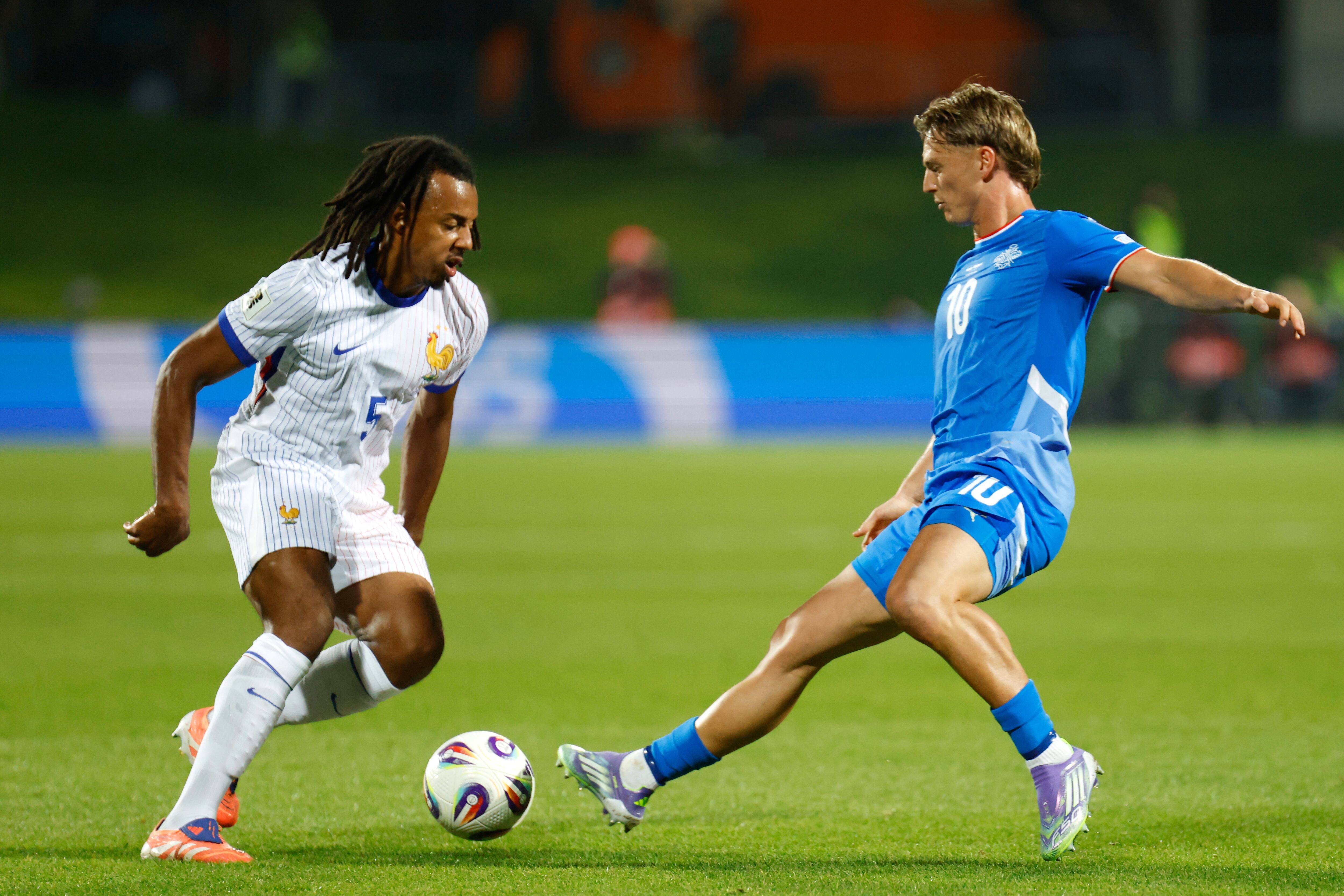 Iceland's Albert Gudmundsson vies for the ball with France's Jules Kounde, left, during a World Cup 2026 group D qualifying soccer match between Iceland and France in Reykjavik, Monday, Oct. 13, 2025. (AP Photo/Brynjar Gunnarsson)