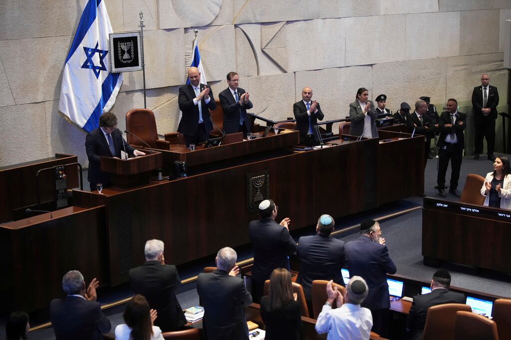 El presidente argentino, Javier Milei, a la izquierda en el podio, es aplaudido por los legisladores en la Knéset, el parlamento israelí, en Jerusalén, el miércoles 11 de junio de 2025. (Foto AP/Ohad Zwigenberg)