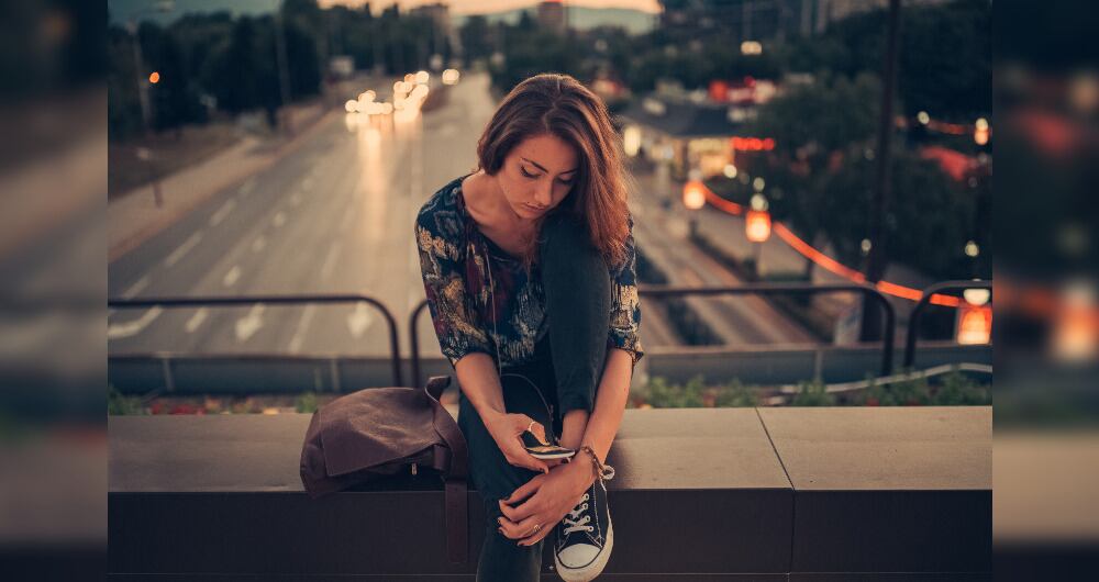 Foto de referencia de una mujer observando el celular