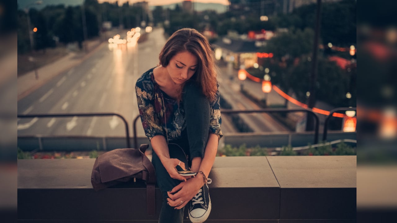 Foto de referencia de una mujer observando el celular