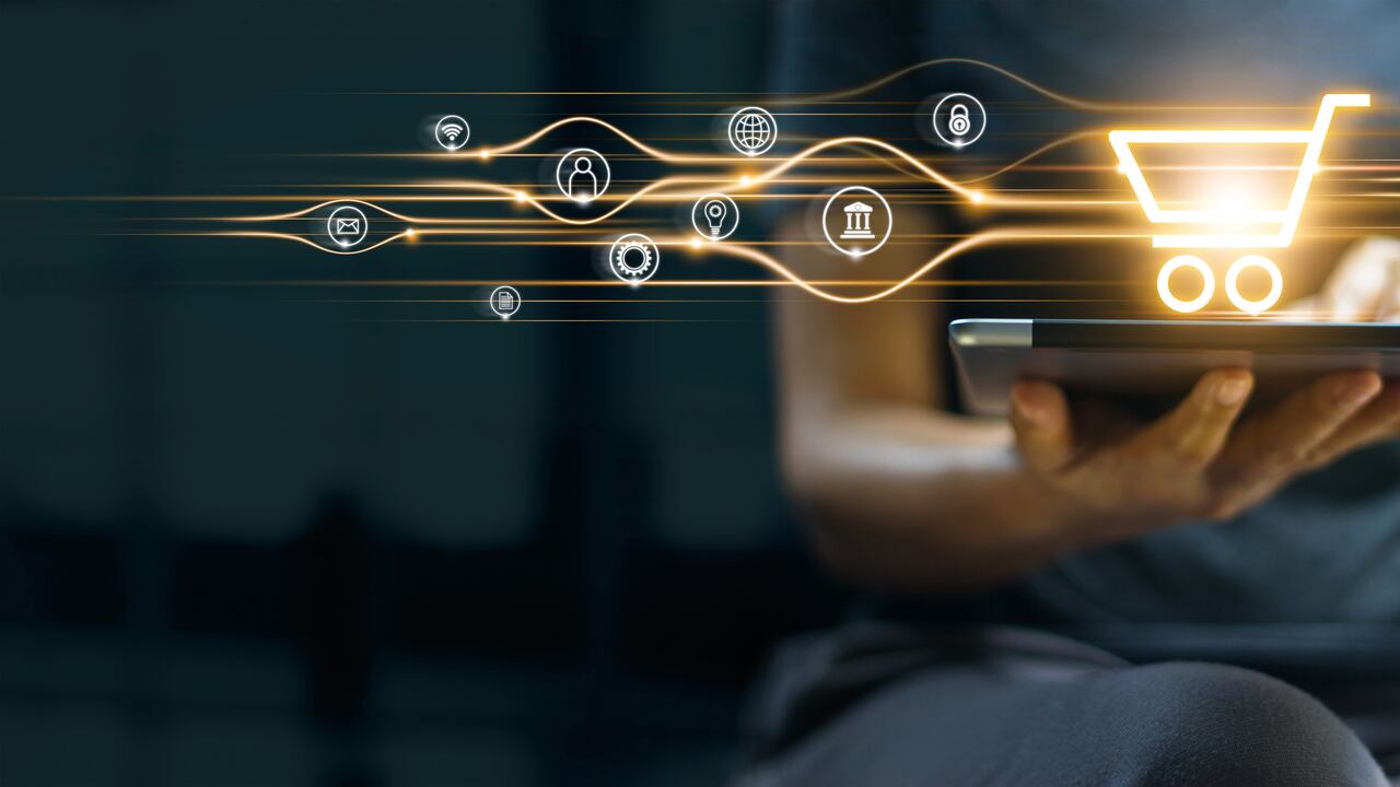 Compras y pagos en línea, hombre usando tableta con icono de carrito de compras, marketing digital, banca y finanzas sobre fondo azul oscuro.