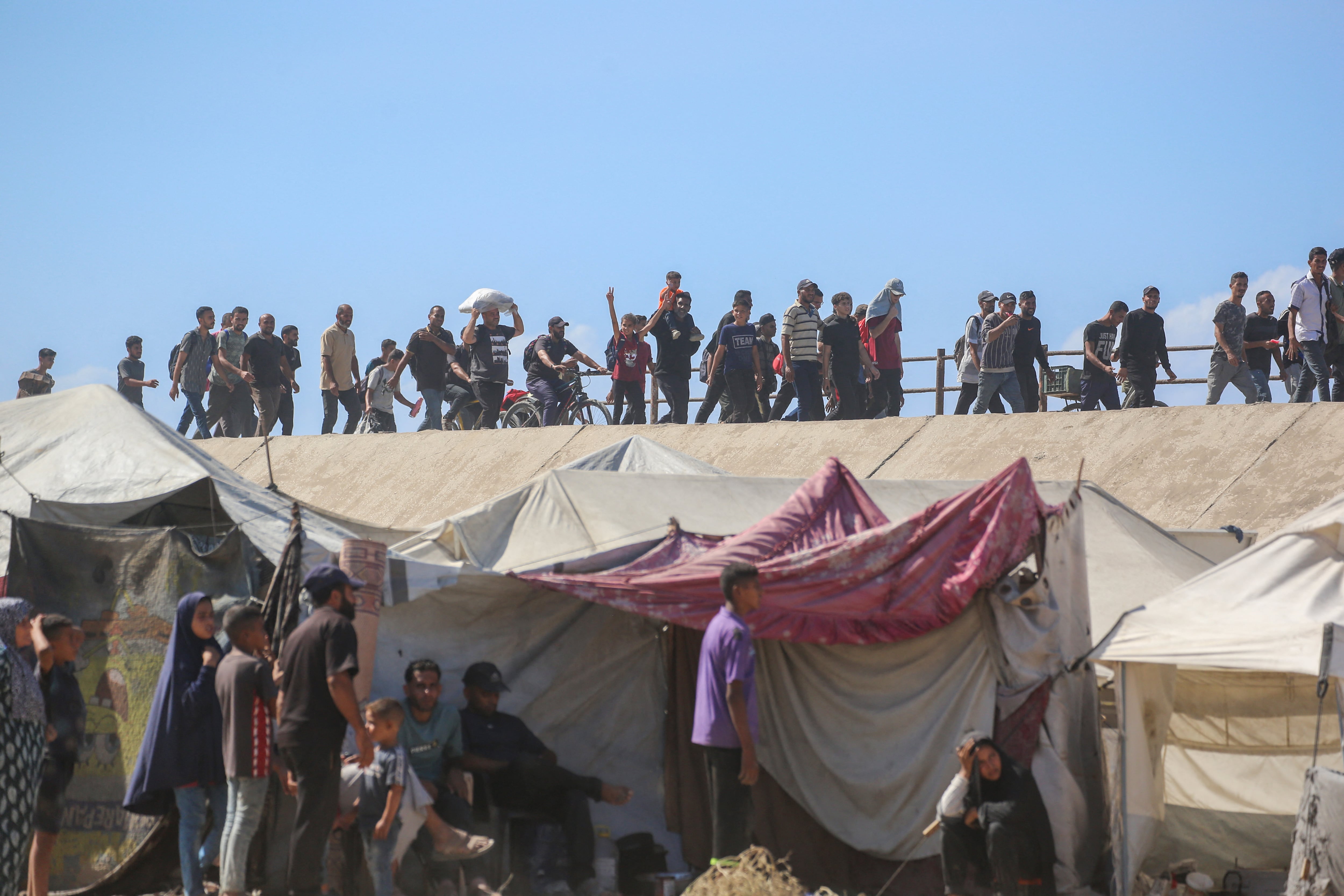 Los palestinos avanzan por la carretera Al-Rashid hacia la ciudad de Gaza desde Nuseirat, en el centro de la Franja de Gaza, el 10 de octubre de 2025. Las fuerzas israelíes declararon un alto el fuego y se retiraron de algunas posiciones en Gaza el 10 de octubre.
