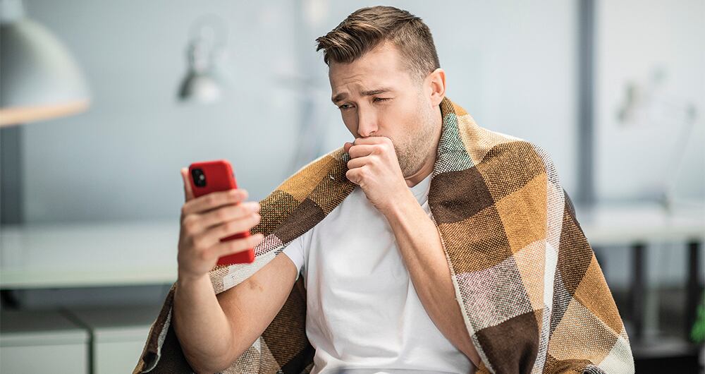 A young office worker is sick with the flu or coronavirus and calls his family on video.