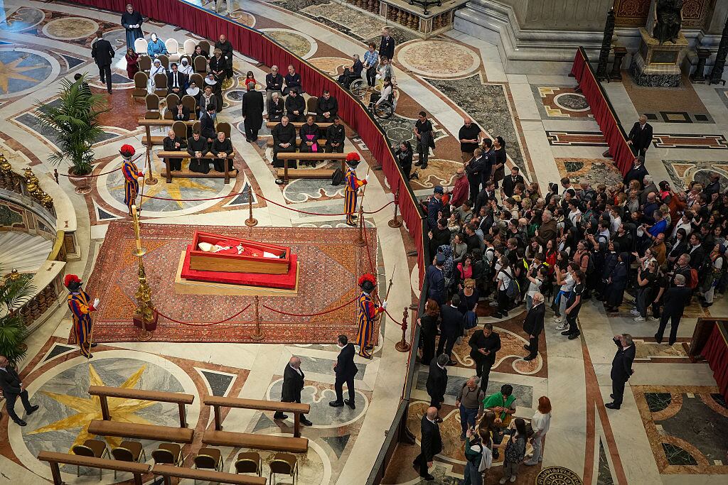 VATICAN CITY, VATICAN - APRIL 23: (EDITORS NOTE: Image depicts death)  Faithful pay their respects as the body of Pope Francis lies in state after being transferred into St Peter's Basilica  on April 23, 2025 in Vatican City, Vatican. On the third day since the death of Pope Francis was announced by the Vatican, his body is transferred from the Chapel of Santa Marta to the Basilica St Peter. He will lie in state in a simple wooden coffin until his funeral, which will be held on Saturday, 26th April 2025.  (Photo by Christopher Furlong/Getty Images)