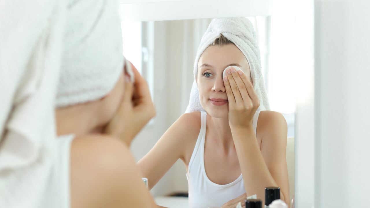 Pretty young woman is cleaning her face