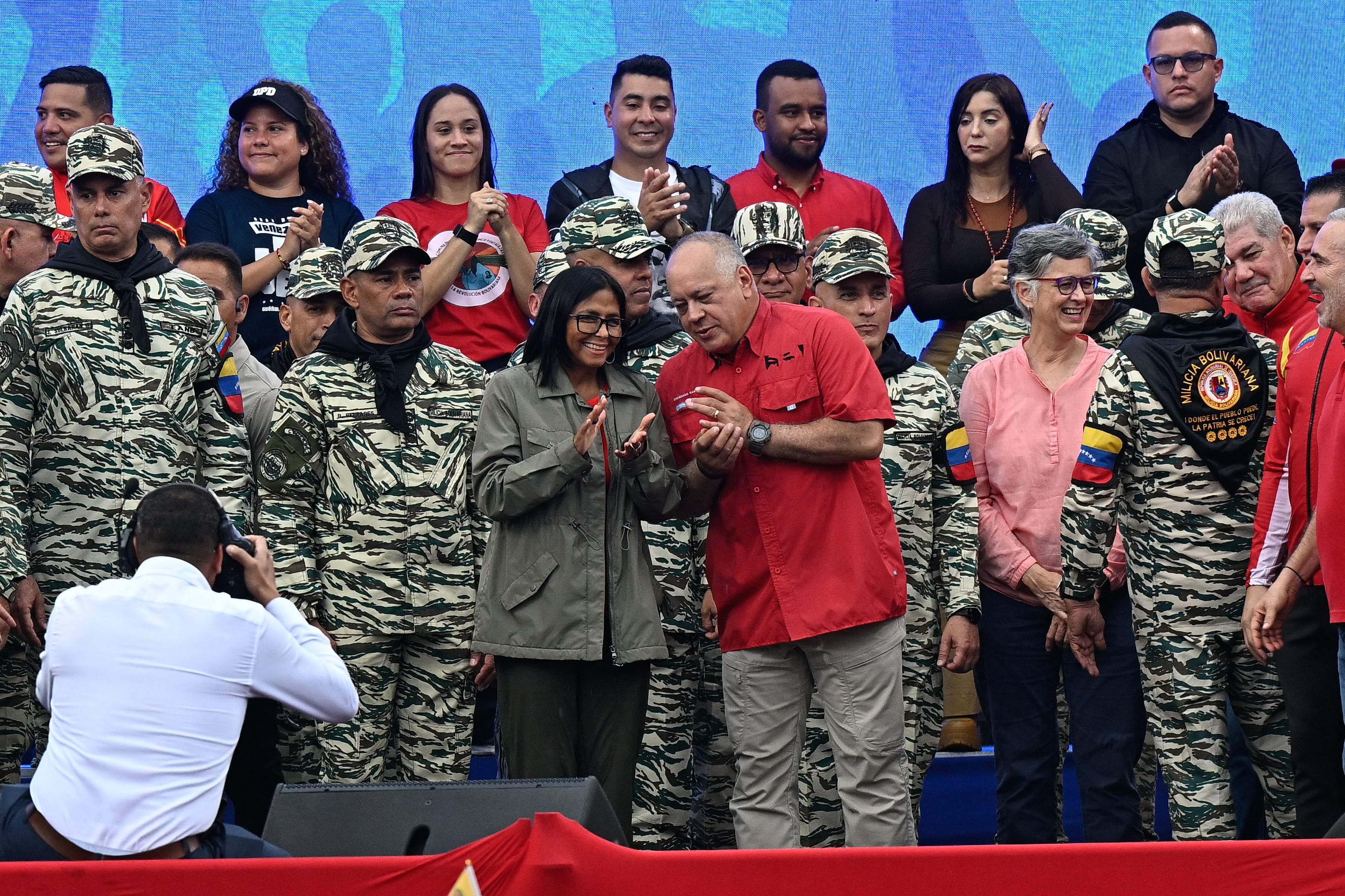La presidenta interina de Venezuela, Delcy Rodríguez (C, izquierda), escucha al ministro del Interior, Justicia y Paz, Diosdado Cabello, durante un desfile cívico-militar