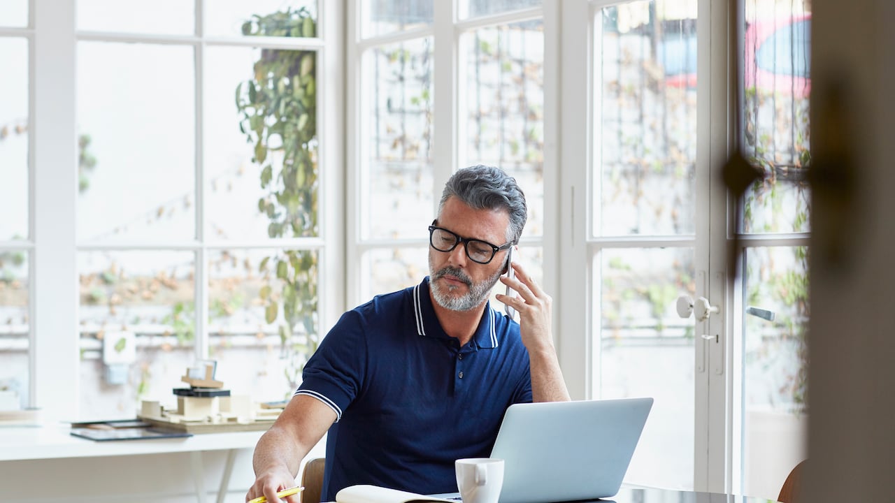 Hombre usa su pc portátil mientras realiza teletrabajo.